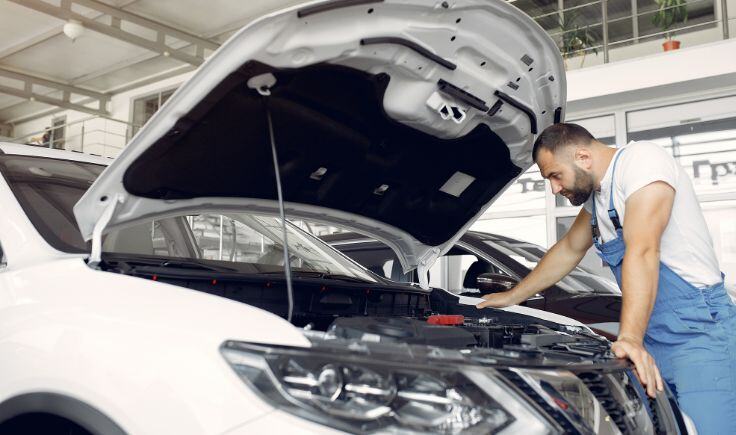 Foto de um mecânico realizando um reparo automotivo no veículo